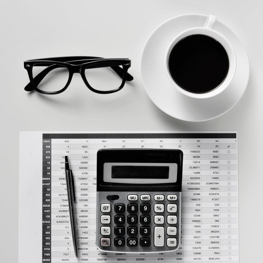 Eyeglasses, Coffee and Calculator on an Office Desk